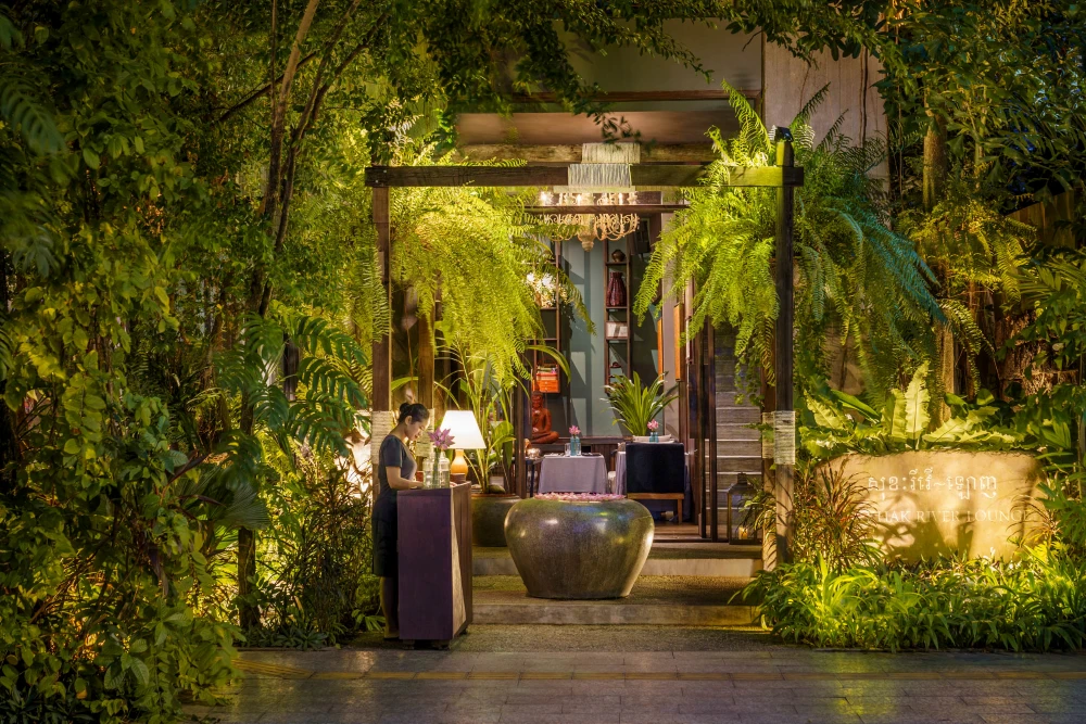 Elegant rustic decor and lush green jungle elements inside Sokkhak River Restaurant by the riverside in Siem Reap