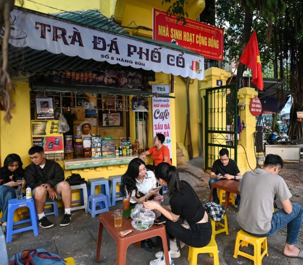 sorseggia un caff&egrave; freddo vietnamita su un piccolo sgabello sul marciapiede