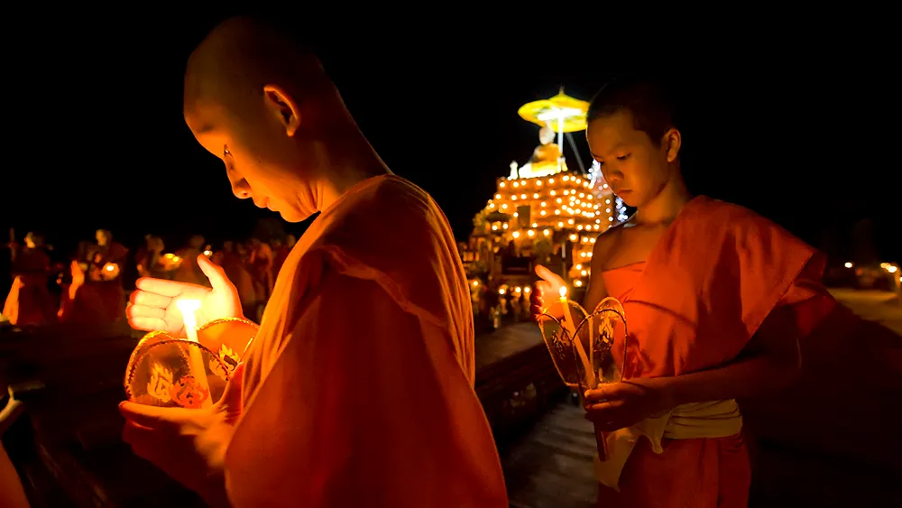 Monks holding lanterns in a procession during a Laos festival