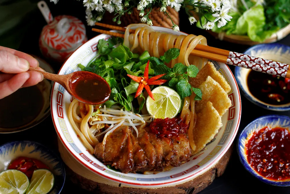 Cao Lau Hoi An specialty noodle dish with pork and herbs traditional street food