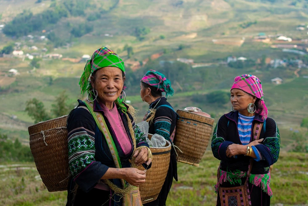 Black Hmong women in traditional indigo costumes with silver jewellery in northern Vietnam