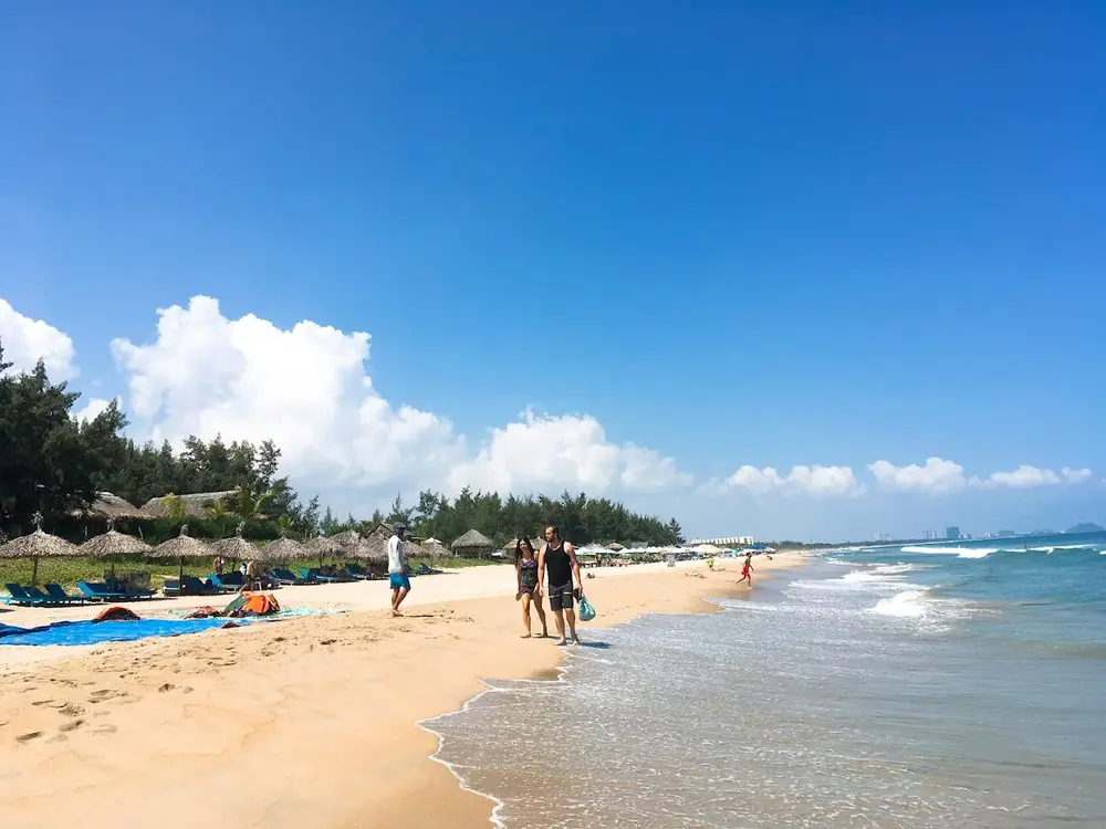 Tourists relaxing by the shore at An Bang Beach