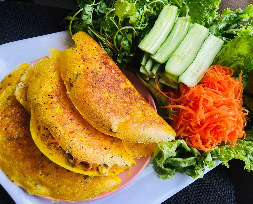 Bánh Xèo served with fresh herbs and salad
