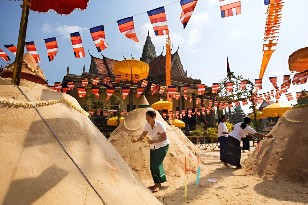 Intricate sand stupas decorated with colourful flags at a Cambodian pagoda during Virak Vanabat