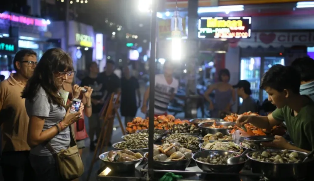 street food vendor cooking snails on Bui Vien Walking Street