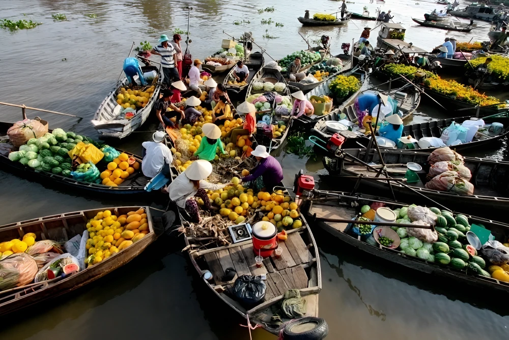 Mercato galleggiante del delta del Mekong con barche cariche di frutta tropicale fresca