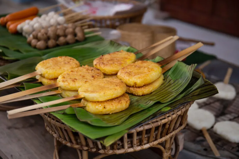 Khao Jee Grilled sticky rice on a stick brushed with egg and grilled over embers, a popular, affordable Laos street food