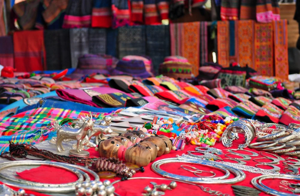 A colourful display of authentic handmade crafts, brocade textiles and fresh produce at a local market in North Vietnam