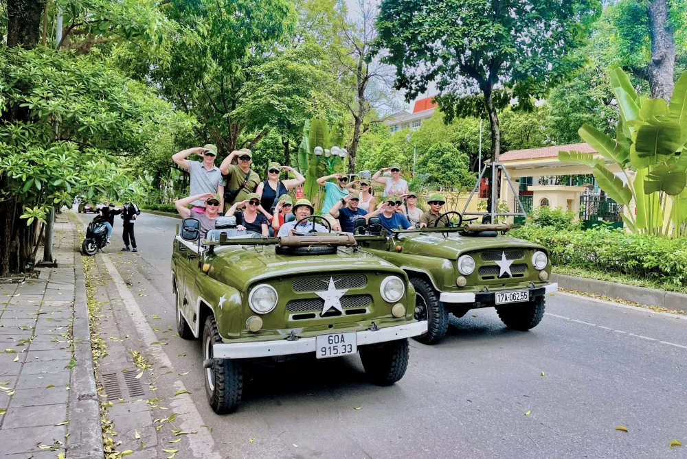 Jeep vintage dell'esercito USA che naviga nel traffico del Quartiere Vecchio di Hanoi