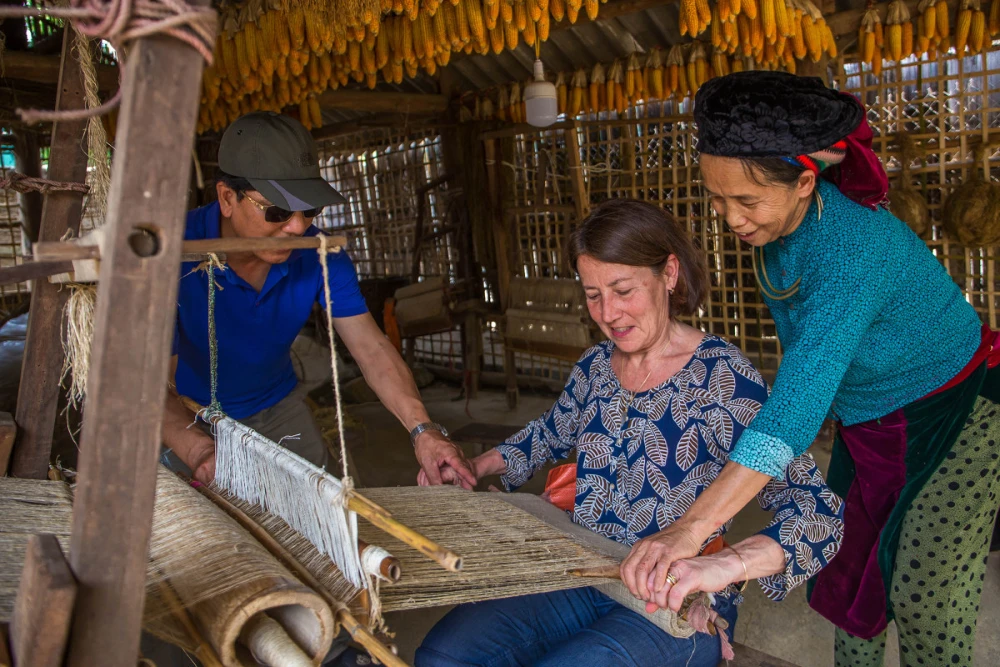 Hmong woman weaving traditional linen with beeswax batik patterns in Lung Tam