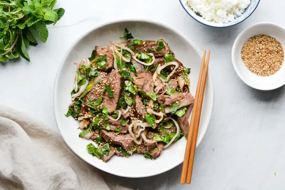Grilled Laotian meat salad Laap Naam Tok with smoky seared beef slices, mixed with fresh coriander, mint, and toasted rice powder