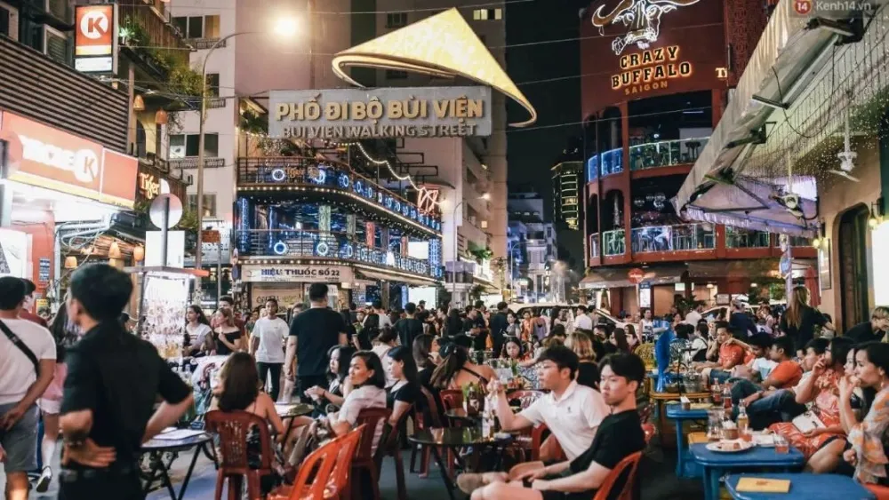 tourists sitting on plastic chairs drinking beer on Bui Vien Street vietnam