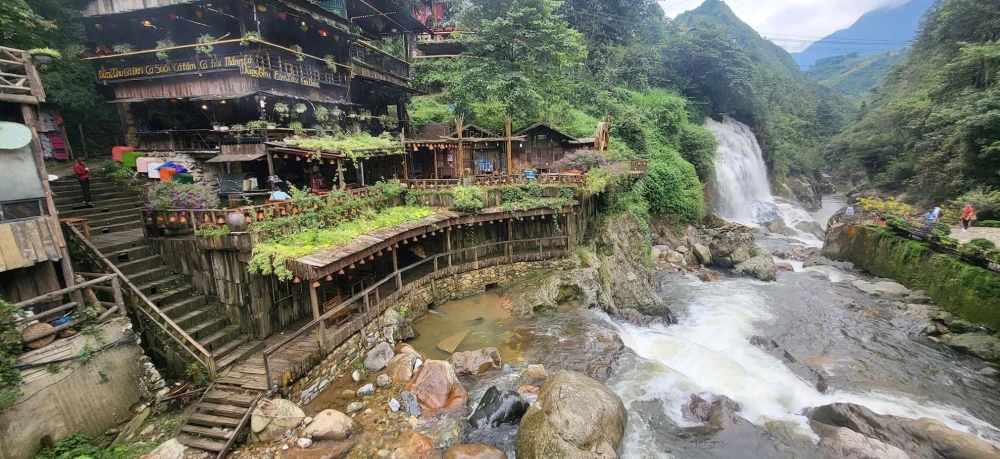 Wooden water wheels and stepping stones across the Muong Hoa stream in Cat Cat Village near Sa Pa