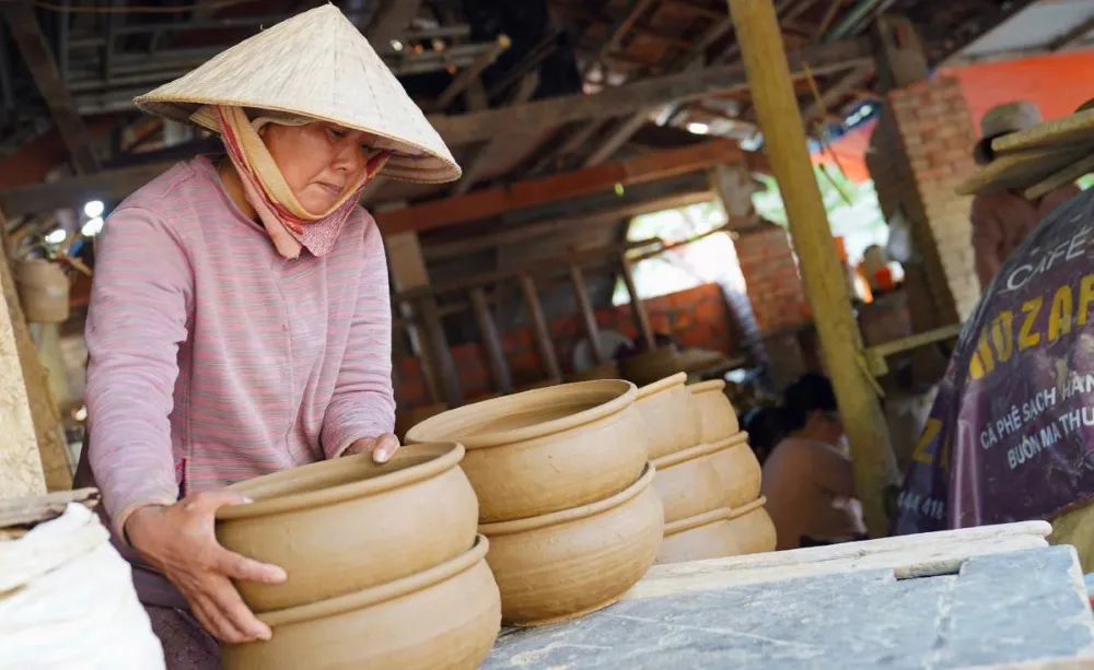 Artisan shaping clay pottery at Thanh Ha Pottery Village Hoi An