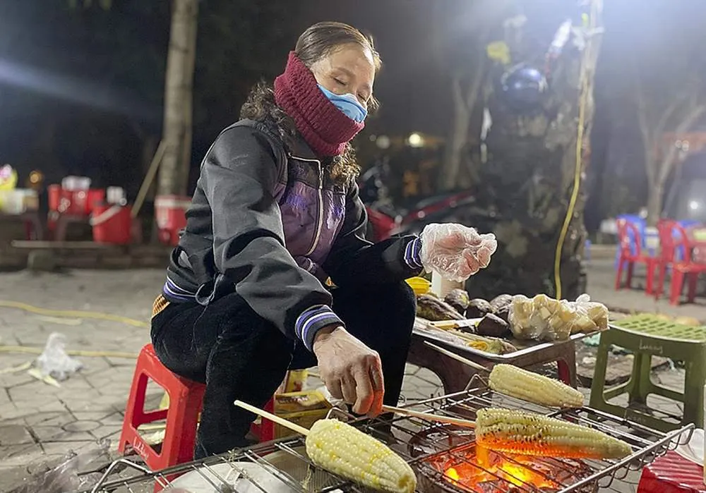 endeur pr&eacute;parant un plat chaud dans une rue du Vieux Quartier de Hano&iuml;